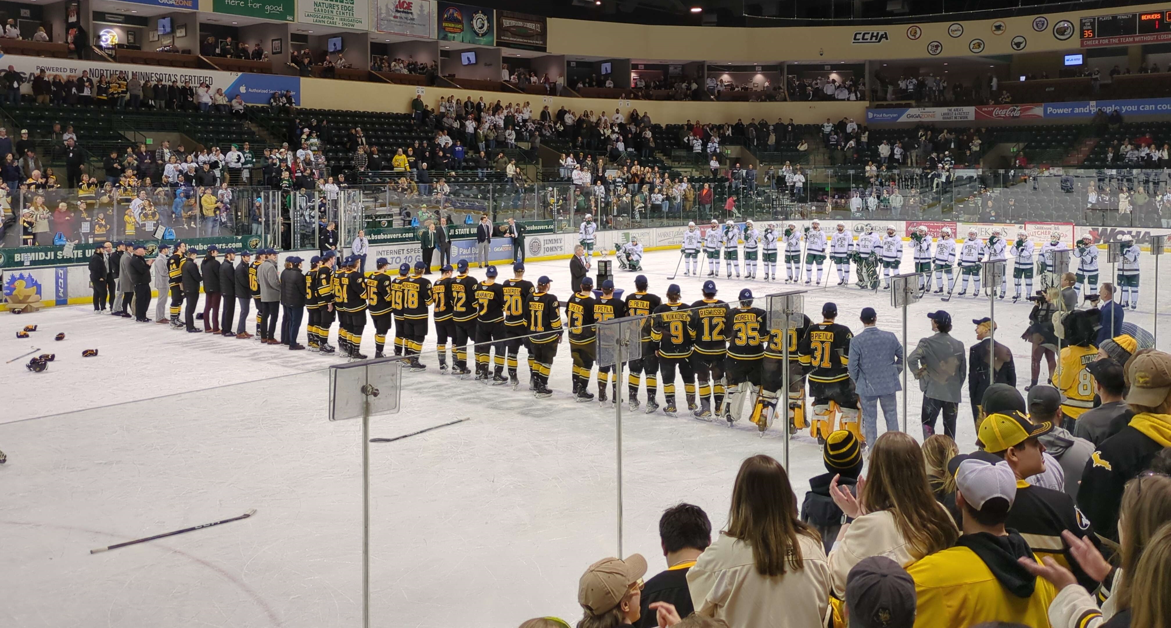 Michigan Tech and Bemidji State players line up for the awarding of the Mason Cup.